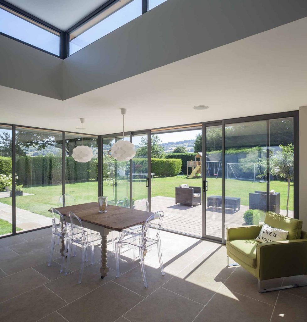 grey sliding door from the interior of a contemporary kitchen, leading to a family garden.